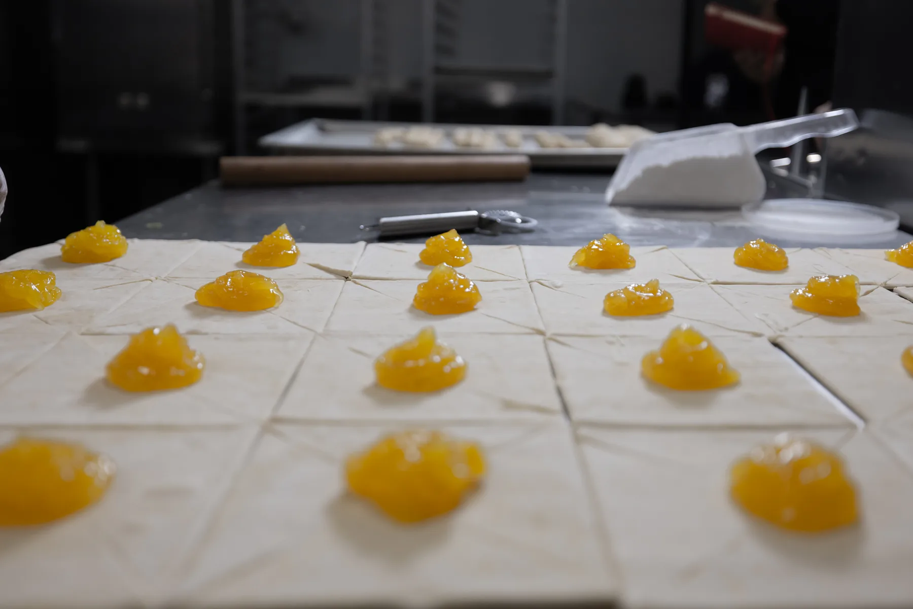 Pastry squares arranged with fruit filling during preparation