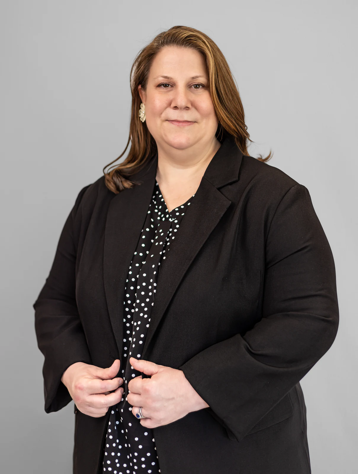 Studio portrait in a black blazer against gray