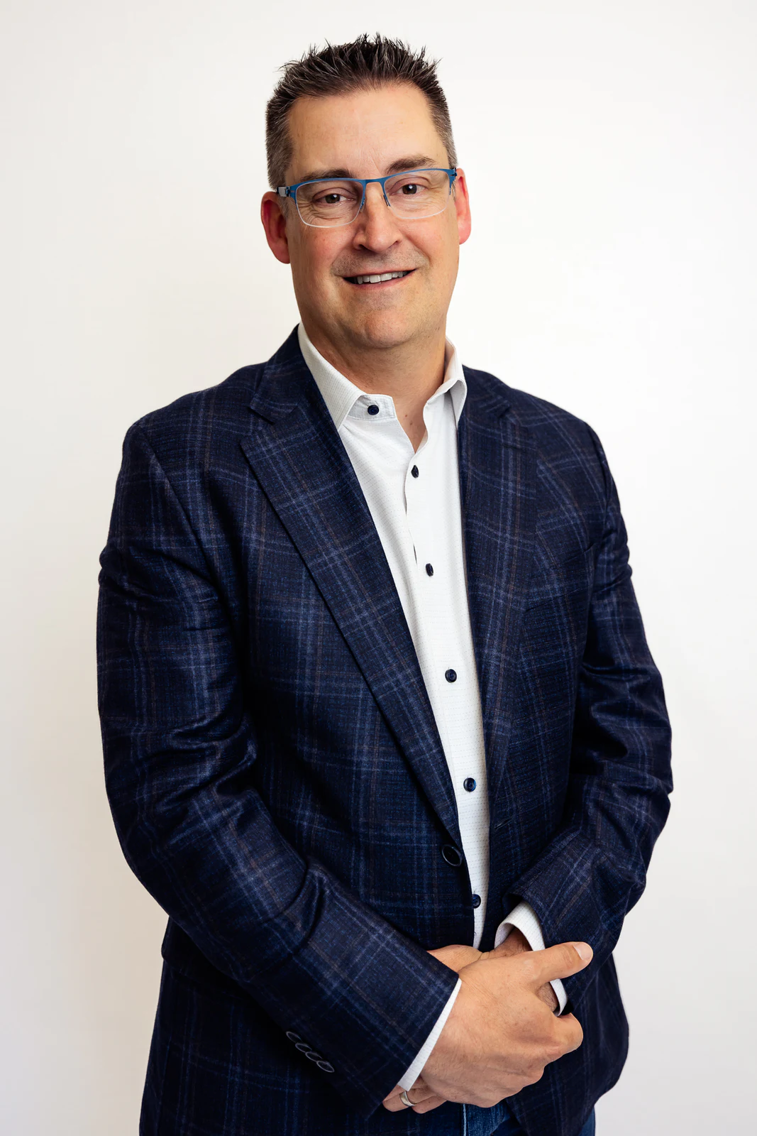 Standing studio portrait in a blue checked suit