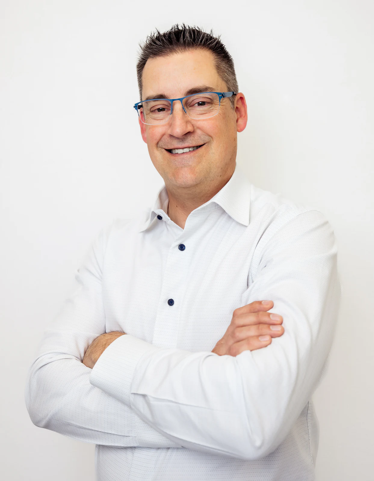 Studio portrait in a white shirt with arms crossed