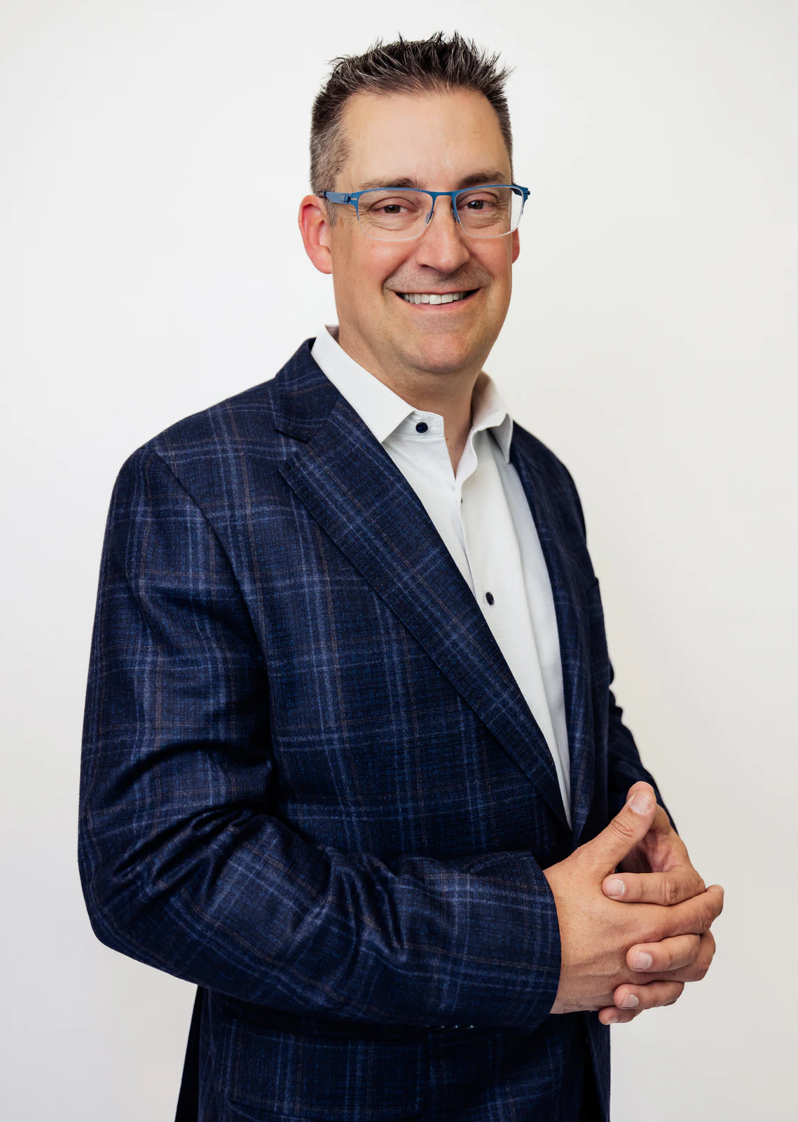 Three-quarter studio portrait in a blue checked suit