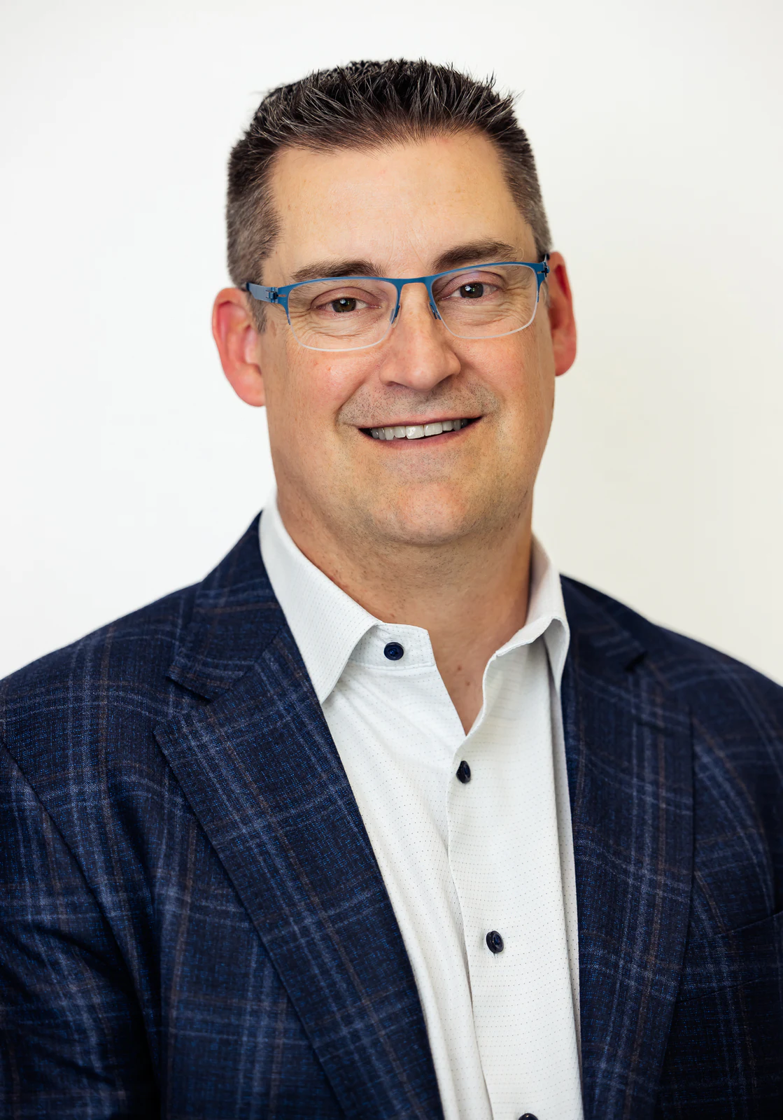 Close professional headshot with blue glasses