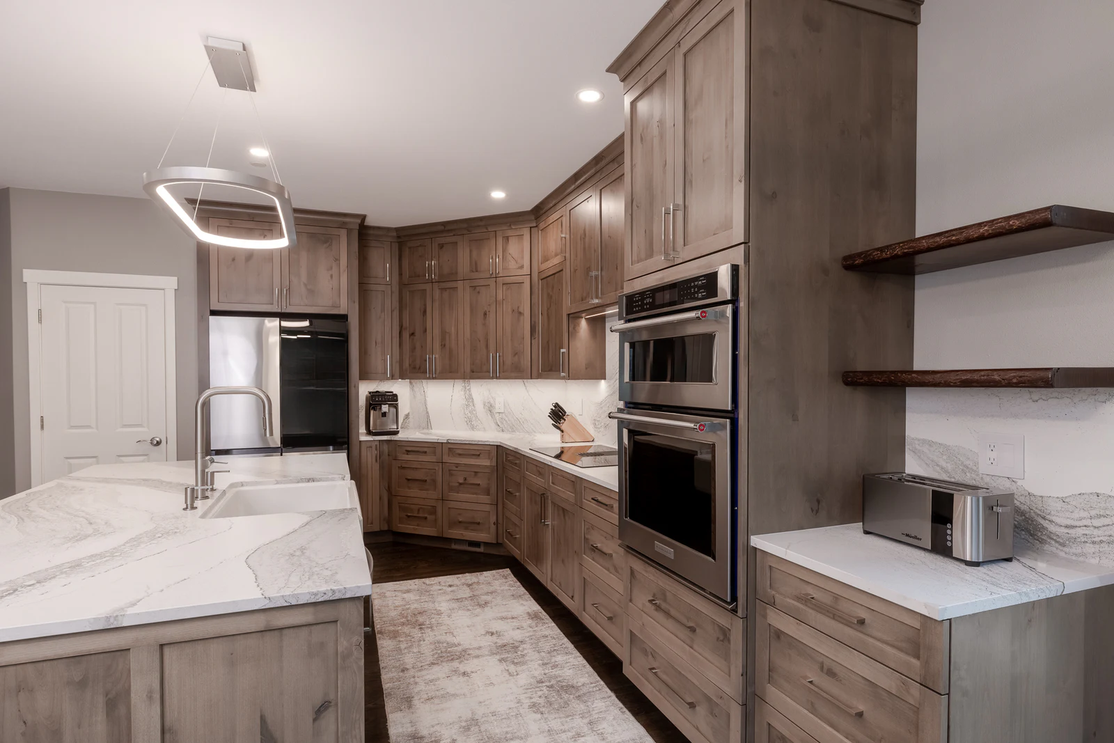Warm wood kitchen viewed across a marble island