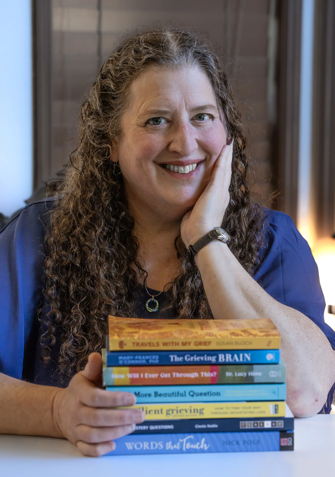 Smiling author portrait with a stack of books