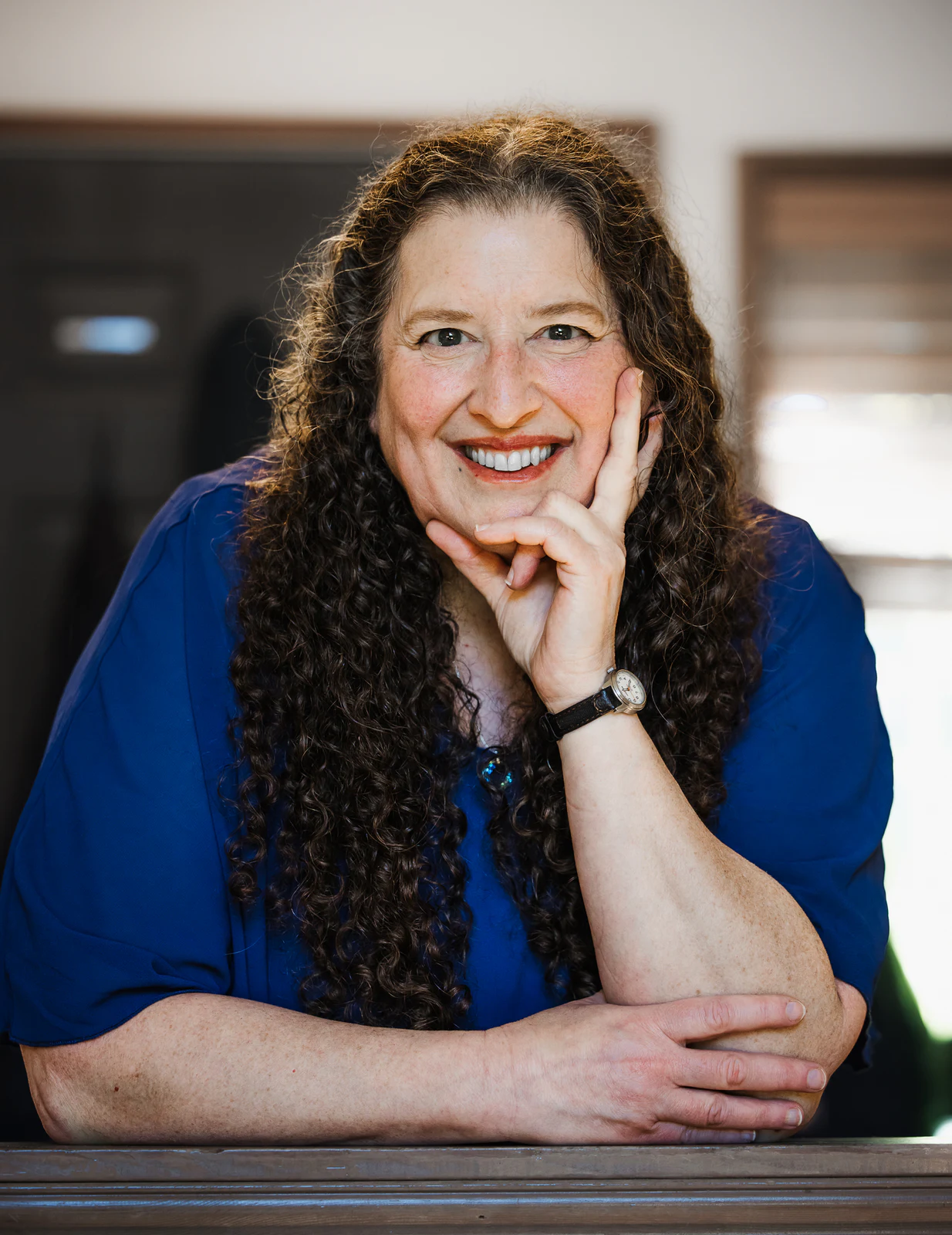 Warm portrait of an author leaning on a kitchen counter
