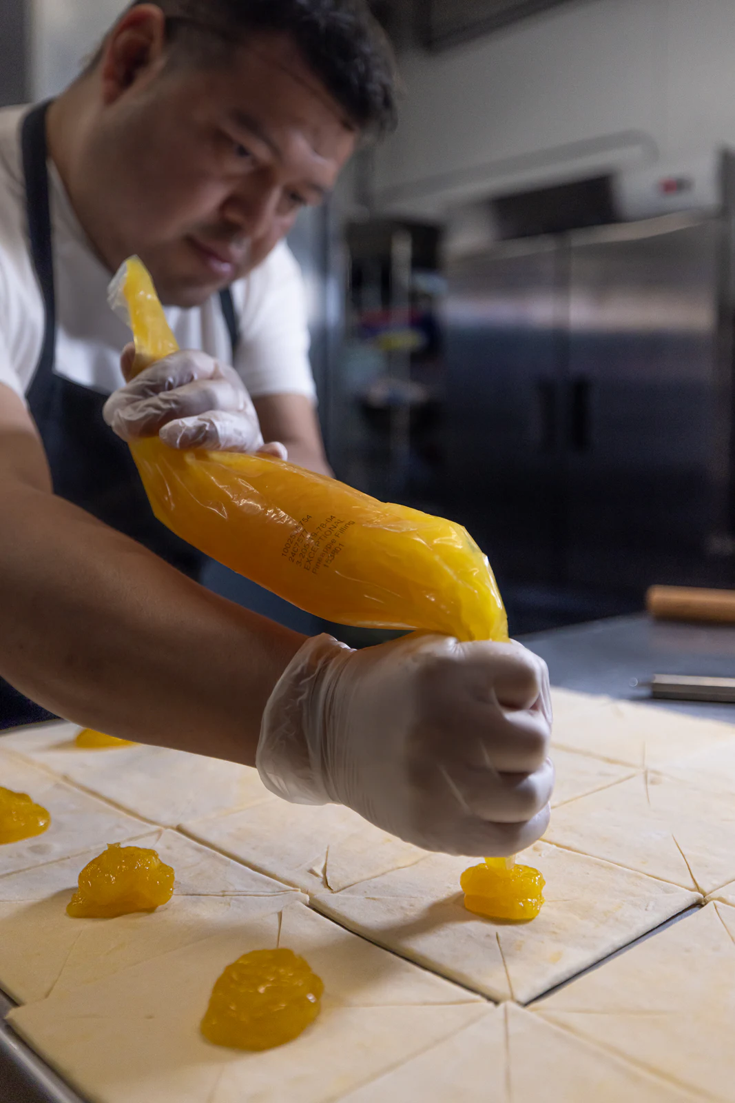 Chef piping bright filling onto pastries